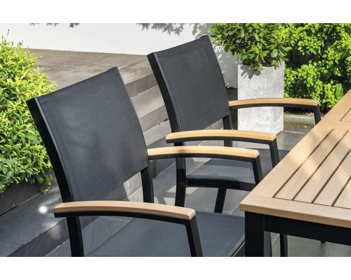 Zwei Gartenstühle mit Armlehnen aus Holz an einem Gartentisch
