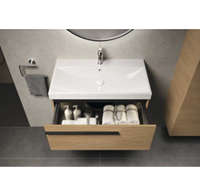 Meuble-lavabo de salle de bains avec tiroir ouvert, serviettes et produits de soins