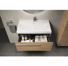 Meuble-lavabo avec tiroir ouvert, serviettes et produits de soin