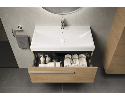 Meuble-lavabo avec tiroir ouvert, serviettes et produits de soin