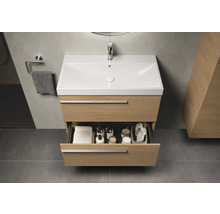 Salle de bains avec meuble sous-lavabo, tiroir ouvert et accessoires