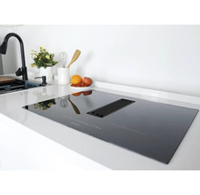 Table de cuisson à induction noire avec hotte intégrée dans une cuisine moderne.