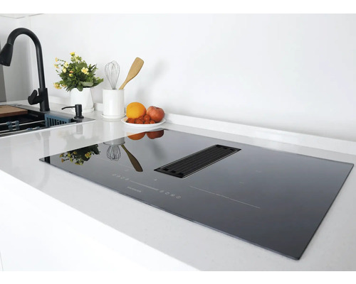 Table de cuisson à induction noire avec hotte intégrée dans une cuisine moderne.