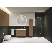 Salle de bain lumineuse avec toilettes, lavabo, miroir, armoire haute et douche