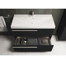 Meuble sous-lavabo avec tiroir ouvert et divers accessoires de salle de bain