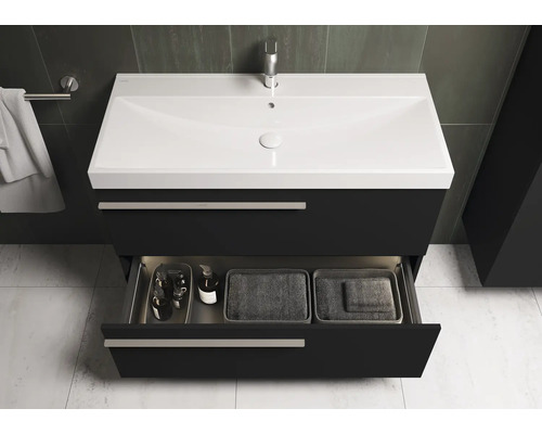 Meuble sous-lavabo avec tiroir ouvert et divers accessoires de salle de bain