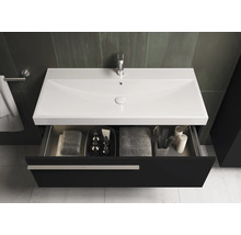 Meuble-lavabo avec tiroir ouvert, serviettes et accessoires de salle de bain