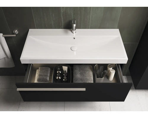 Meuble-lavabo avec tiroir ouvert, serviettes et accessoires de salle de bain