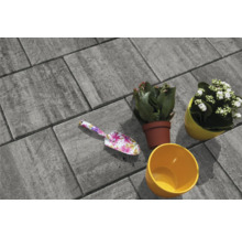 Pavés gris avec truelle à fleurs et pots de fleurs plantés