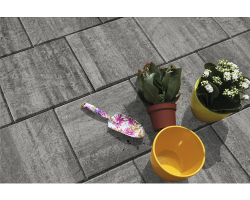 Pavés gris avec truelle à fleurs et pots de fleurs plantés