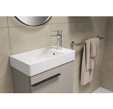Badezimmer Waschbecken mit Unterschrank, Armatur und Handtuchhalter.