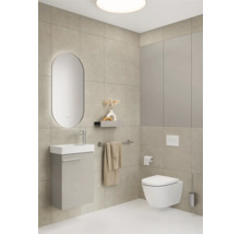 Badezimmer mit Waschbecken, Spiegel, Toilette und Handtuchhalter