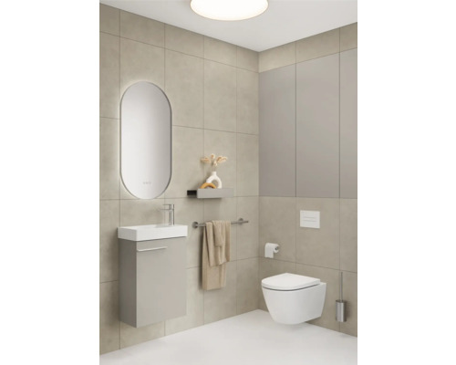Badezimmer mit Waschbecken, Spiegel, Toilette und Handtuchhalter