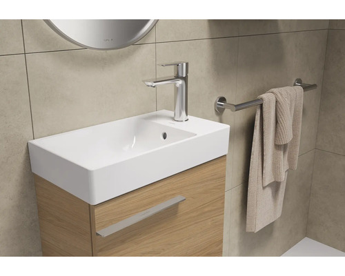 Lavabo avec robinet, serviette et porte-serviettes dans la salle de bain