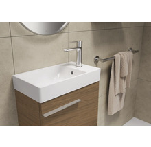 Badezimmerwaschtisch mit Armatur, Handtuch und Handtuchhalter.