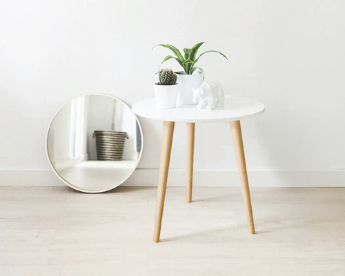 Scène décorative avec un miroir, une table avec des plantes et une figurine d'ours.