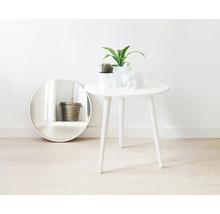 Scène décorative avec miroir rond, table d'appoint, plantes d'intérieur et sculpture