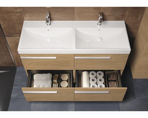 Meuble-lavabo avec deux vasques, robinets et tiroirs contenant des serviettes et du papier toilette pour l'aménagement de la salle de bains