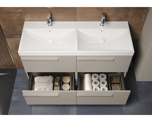 Meuble sous-vasque avec deux lavabos, robinets et tiroirs ouverts pour ranger les articles de toilette