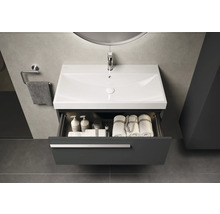 Meuble-lavabo avec tiroir ouvert, avec des serviettes et des produits de soin à l'intérieur
