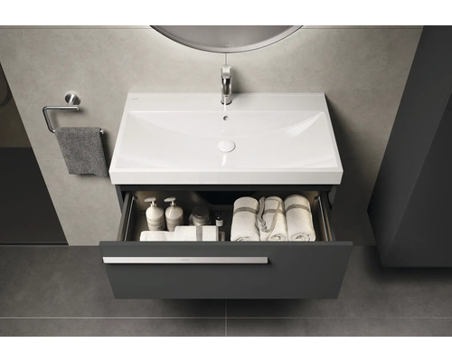 Meuble-lavabo avec tiroir ouvert, avec des serviettes et des produits de soin à l'intérieur