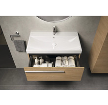 Meuble sous-lavabo avec tiroir ouvert et divers accessoires de salle de bain