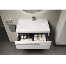 Meuble-lavabo avec tiroir ouvert, comprenant des serviettes et des produits de soin dans la salle de bain.