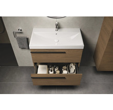 Meuble sous-lavabo avec tiroir ouvert, serviettes et accessoires de salle de bain