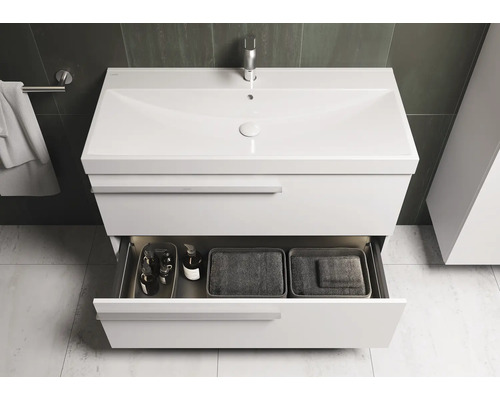 Meuble sous-vasque avec tiroir et accessoires de rangement dans la salle de bain.