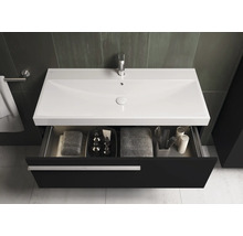 Meuble sous-lavabo avec tiroir ouvert, serviettes et articles de bain