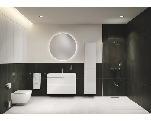 Salle de bain moderne avec toilettes, lavabo, miroir et douche.