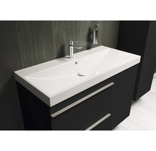 Meuble-lavabo avec meuble sous-vasque, robinet et distributeur de savon dans la salle de bains.