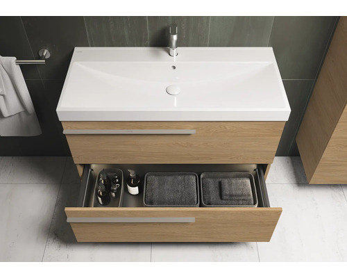 Meuble sous-lavabo avec tiroir ouvert, comprenant un lavabo et un robinet dans la salle de bain