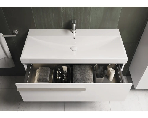 Meuble-lavabo blanc avec tiroir ouvert dans une salle de bain.