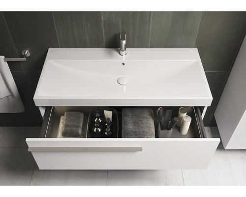 Meuble-lavabo avec tiroir ouvert, serviettes et accessoires de salle de bain