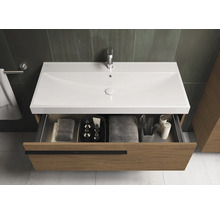 Meuble sous-vasque avec tiroir ouvert, équipé de serviettes et d'accessoires de salle de bain.