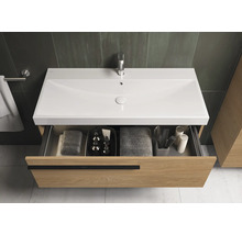 Meuble sous-lavabo avec tiroir ouvert, serviettes et accessoires de salle de bain