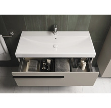 Meuble sous-lavabo avec tiroir ouvert et divers accessoires de salle de bain