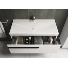 Meuble-lavabo avec tiroir ouvert, comprenant des serviettes et des accessoires de salle de bain