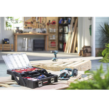 Werkstattszene mit Werkzeugkiste, Kreissäge und Bohrmaschine auf Holzbalken