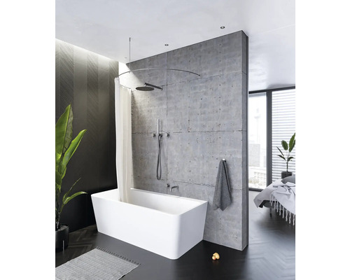 Badezimmer mit freistehender Badewanne, Duschvorhang und Betonwand