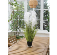 Dekorative Kunstpflanze mit Federn in einem Topf auf einem Holztisch
