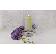 Bougie décorative à rainures sur un support en verre avec une orchidée violette