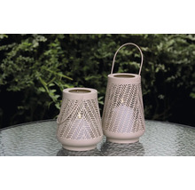 Zwei dekorative Windlichter mit Griff und Lochmuster auf einem Tisch