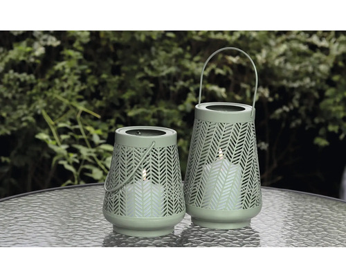 Zwei dekorative Windlichter mit Muster und Henkel auf einem Tisch