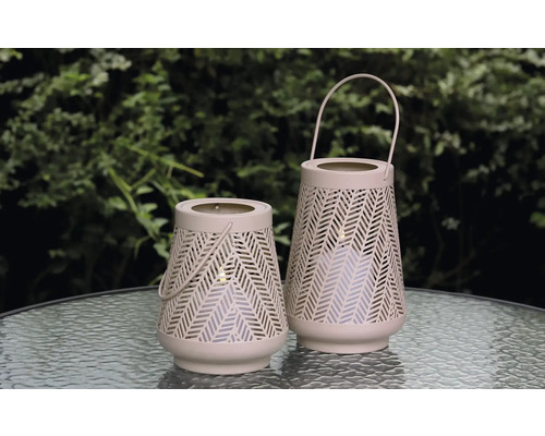 Zwei dekorative Windlichter mit Tragegriffen und geometrischem Muster stehen auf einem Tisch.