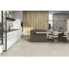 Cuisine claire et moderne avec îlot de cuisine, coin repas et carrelage.