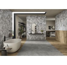 Salle de bain lumineuse avec baignoire îlot, lavabo et carrelage gris