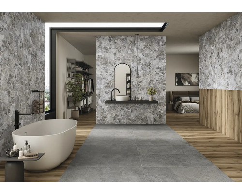 Salle de bain lumineuse avec baignoire îlot, lavabo et carrelage gris