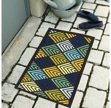 Paillasson avec motif géométrique devant une porte d''entrée